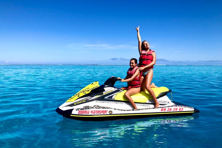 a person riding on the back of a boat on a body of water